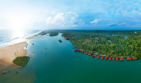 Aerial view of the Poovar estuary, golden sand beach and floating cottages