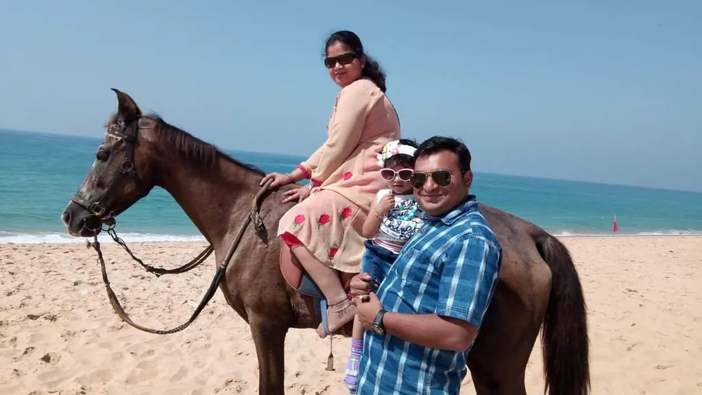Family enjoying a horse ride on Poovar golden sand beach