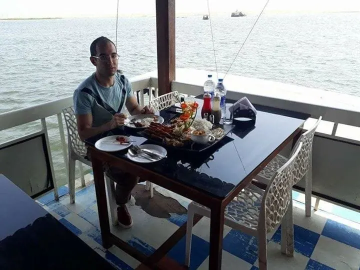 Guest having lunch on a floating restaurant overlooking the Poovar backwaters